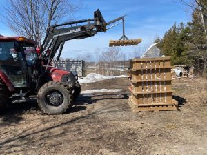 Tractor placing lid on pallet system